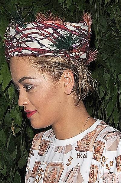 Rita Ora arriving at a studio, wearing a jumpsuit covered in dollar signs, and a headscarf