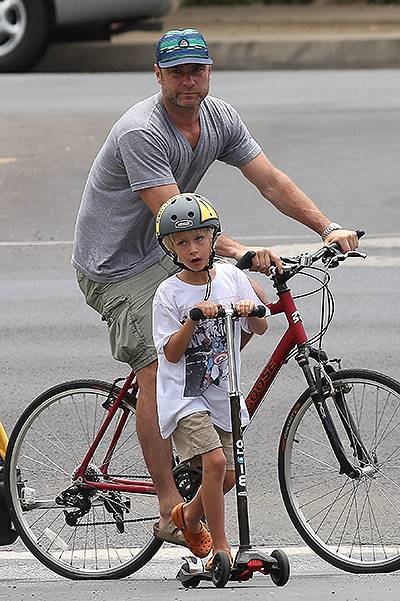 Naomi Watts and Liev Schreiber riding bicycles with their children in Los Angeles